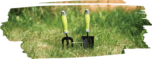a lawn fork and a small shovel placed inside the soil